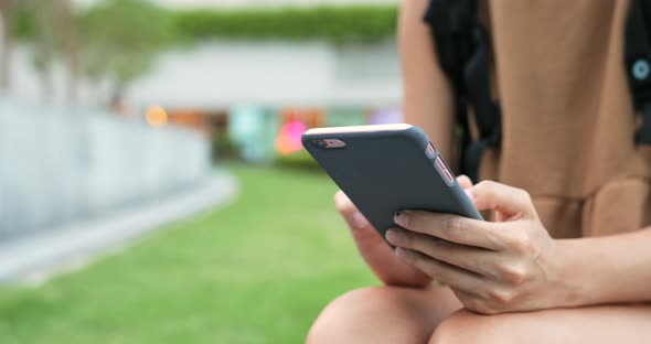 Woman using smart phone in city park