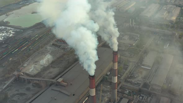 Industrial Zone with a Large Red and White Pipe Thick White Smoke Is Poured From the Factory Pipe