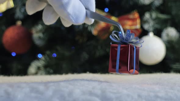 Santa Claus Puts a Gift Near the Decorated Christmas Tree