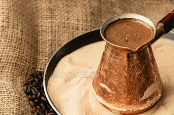 Turkish coffee prepared in sand with turk / Photodune, Misc