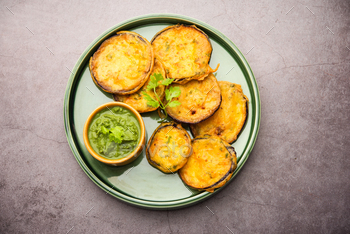 Tasty Brinjal Pakora or crispy eggplant fritters, Indian tea time snack served with green chutney / Photodune, Misc