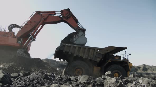 Blue Sky Over Coal Deposit and Heavy Equipment Working in It for Extraction of Energy Raw Materials