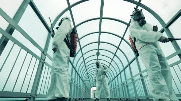 Disinfectors Are Spraying Chemicals in a Pedestrian Tunnel