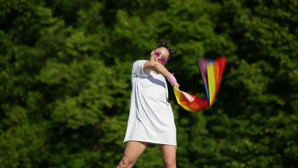 Young Woman Waving LGBT Pride Flag in the Park