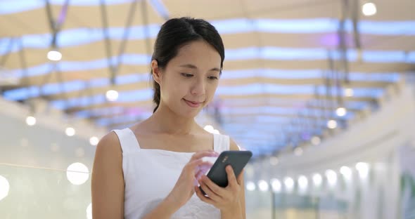 Woman look at mobile phone inside shopping center