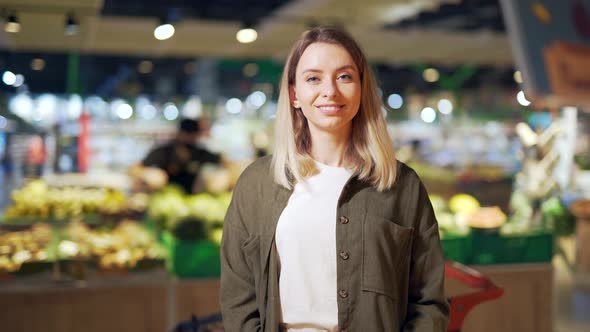 young woman chooses and picks in eco bag vegetables or fruits Oranges in the supermarket. 