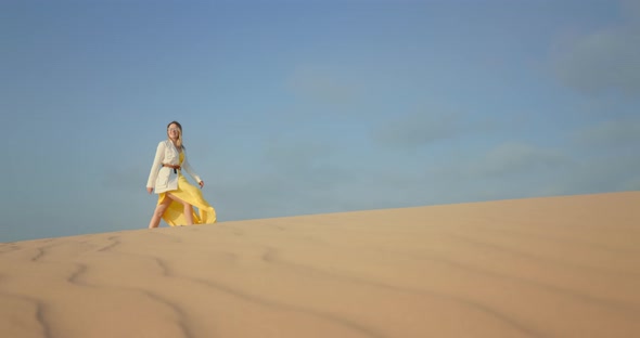 Blue Space for Copy or Text on Background with Woman Walking By Wavy Sand