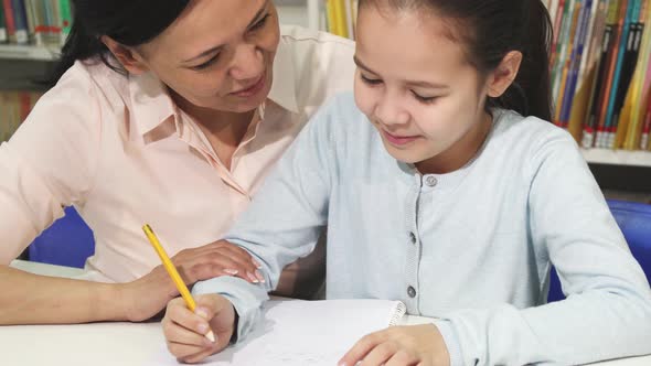 Adorable Little Girl Doing Homework with Her Mother
