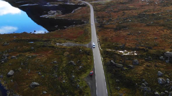 drone flying over street and van is passing under it. In Norway in the lofotes.