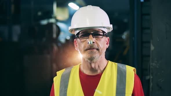 Male Industrial Worker in a Hardhat Is Looking at the Camera