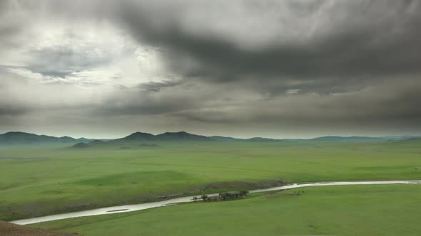 Big River and Gray Storm Clouds on the Vast Meadow in Mongolia