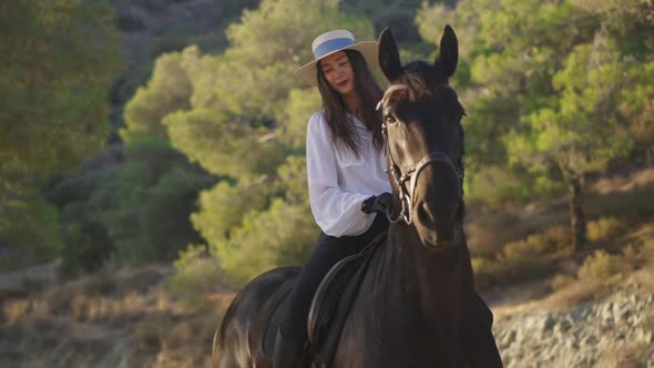 Beautiful Young Equestrian Smiling Looking at Camera Sitting on Back of Purebred Horse