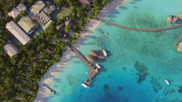 Aerial view of overwaters bungalows connected by a footbridge, Maldives island.