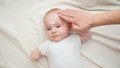 Closeup of mother applying moisturizing cream on her little baby face skin. Concept of newborn baby - PhotoDune Item for Sale