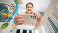 Happy smiling mother making video of her baby lying in cradle for social media. Concept of parenting - PhotoDune Item for Sale