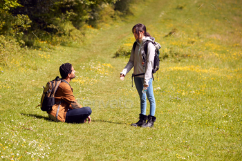 Couple With Backpacks Taking A Break On Hike Along Path Across Field By Forest In Countryside / Photodune, Misc