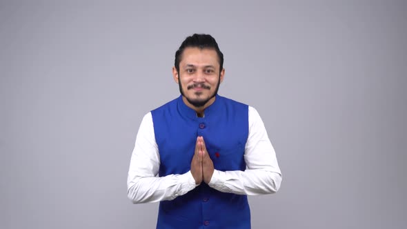 Indian man doing Namaste in Indian traditional wear