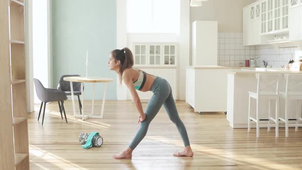 Sporty Young Woman Is Making Lunge in Yoga Pose in Stretching Legs at Home.