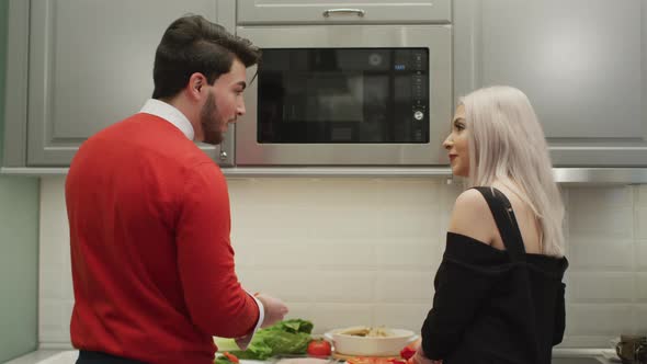 Couple talks as they work in the kitchen