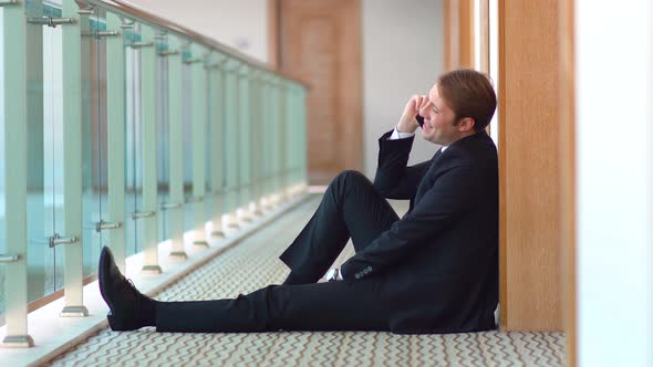 Businessman talking on the phone. Corridor.