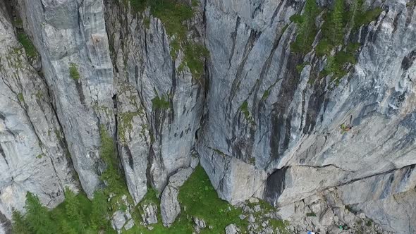 Aerial drone view of a man rock climbing up a mountain.