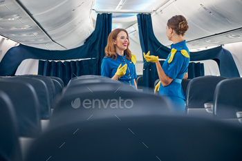 g blue flight attendant uniforms while standing in the empty hall of passenger aircraft