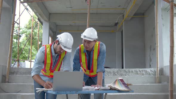 Young Asian engineers and caucasian engineer colleagues at site inspector and discuss together