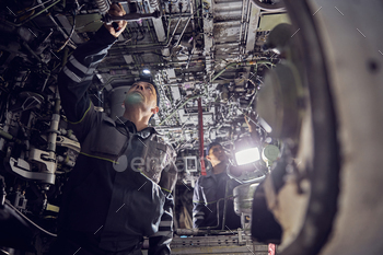 屋内で飛行機を修理する航空機労働者 / Photodune, Misc