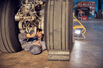 Man is working on airplane under wheels / Photodune, Misc