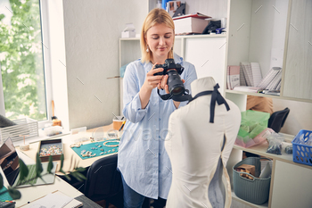 Smiling female taking a picture in work studio / Photodune, Misc