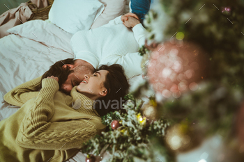 Cinematic image of a couple celebrating christmas at home. / Photodune, Misc
