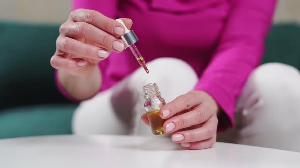 Close Up Woman Hands with Glass Droplet Bottle of Essential Oils