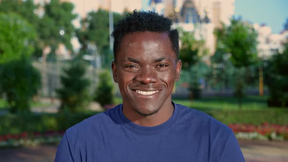 Close Up Smiling Afroamerican Man Looks Camera on Background Park in Summer