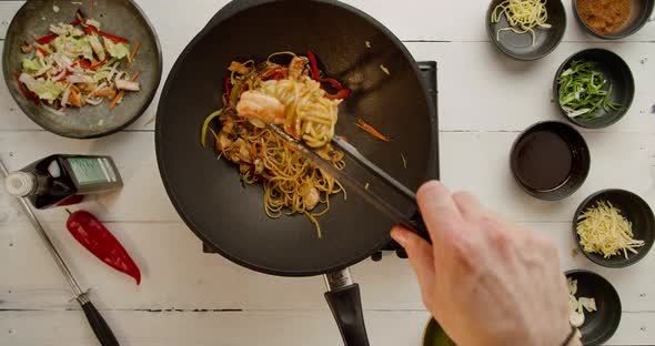 Professional Cook Frying Vegetables with Noodles