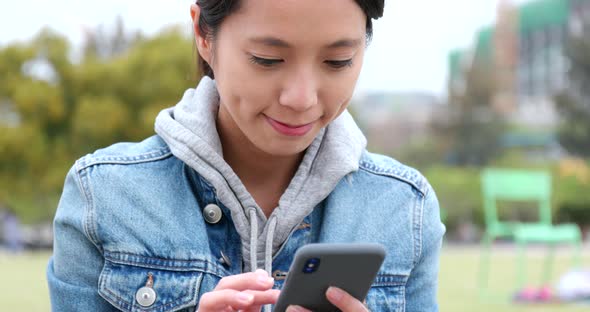 Young woman use of mobile phone at outdoor park