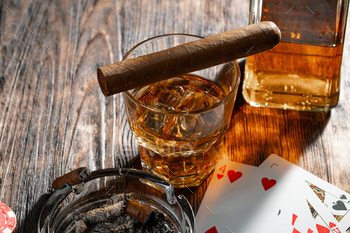 Playing poker with whiskey and cigars on table / Photodune, Misc