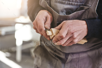 Quality is not an act. It is a habit. Carpenter using chisel to carve wood in workshop / Photodune, Misc