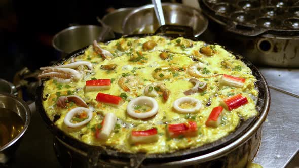 Traditional seafood omelet on an flat grill street food market, Bangkok