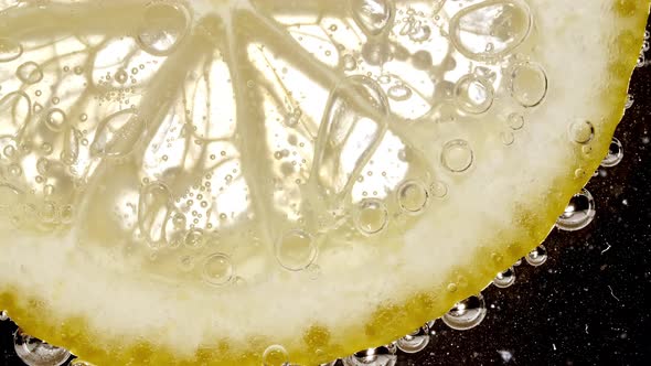 Water with Lemon Slices and Exploding Soda Air Bubbles