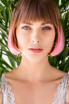 Portrait of young attractive woman with pink hair standing amongst leaves and looking at camera / Photodune, Misc