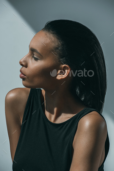 灰色で目をそらしている黒い服を着たアフリカ系アメリカ人のトレンディな女性のプロフィールの肖像画 / Photodune, Misc