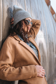 Side view of stylish woman in autumn outfit and black sunglasses standing outside / Photodune, Misc