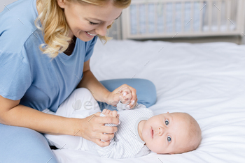 自宅のベッドで幼児の赤ちゃんと遊ぶ幸せな母親 / Photodune, Misc