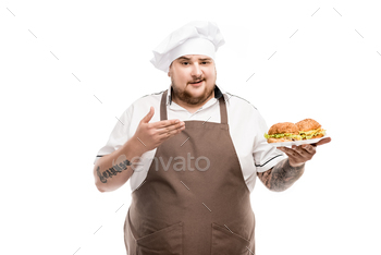 smiling cooker pointing at burgers on plate isolated on white / Photodune, Misc