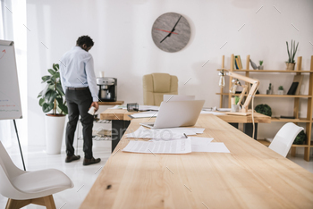 lonely tired businessman standing at conference hall with paperwork on table / Photodune, Misc