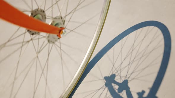 Road bike wheel spinning and casting shadow over a concrete road. Loop animation