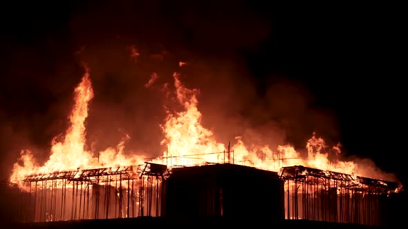 Slow motion burning fire flame on residential building roof at night