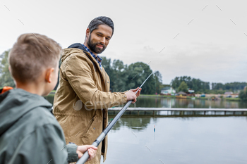 happy father and son fishing together with rod on lake / Photodune, Misc