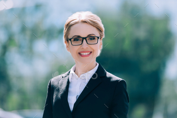 portrait of beautiful blonde mature businesswoman in eyeglasses smiling at camera / Photodune, Misc