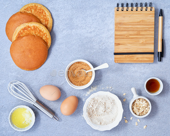 Ingredients for pancake recipe, notebook in a pen on light blue background. / Photodune, Misc